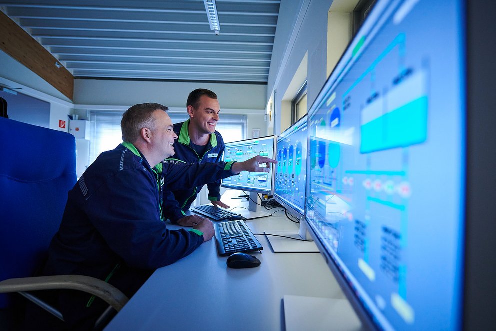 Zwei Techniker in Blaumann vor Monitoren