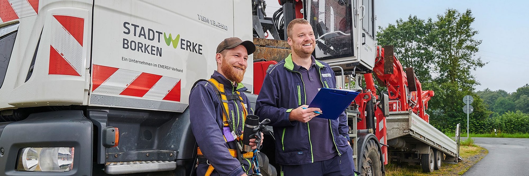 Zwei Arbeiter vor einem Hubsteigerfahrzeug der Stadtwerke Borken