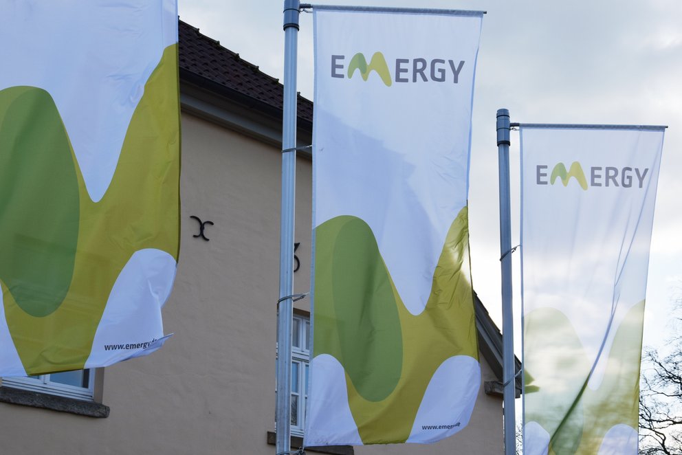 Fahnen mit Emergy-Logo vor Gebäude