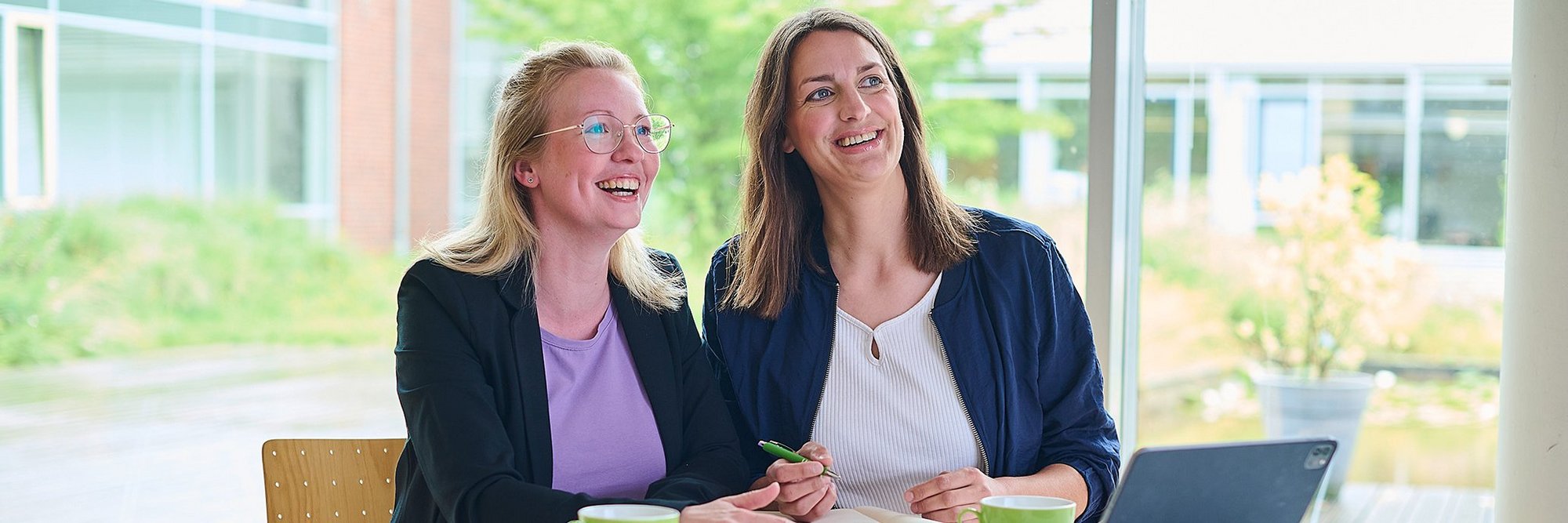 Zwei Frauen am Schreibtisch vor einem Laptop