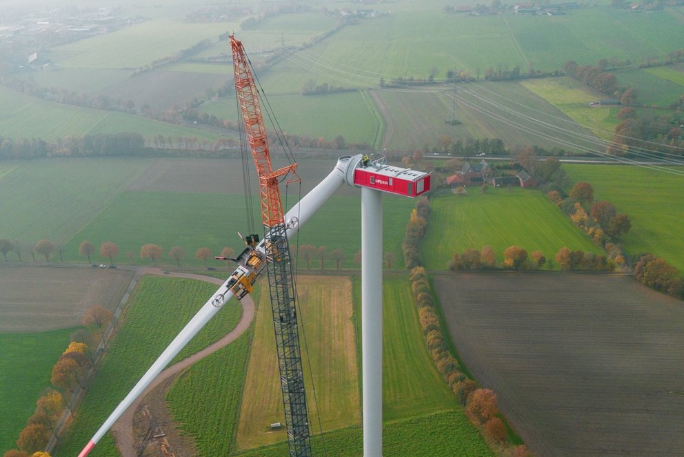 Windkraftanlage im Aufbau mit Kran. Drohnenansicht