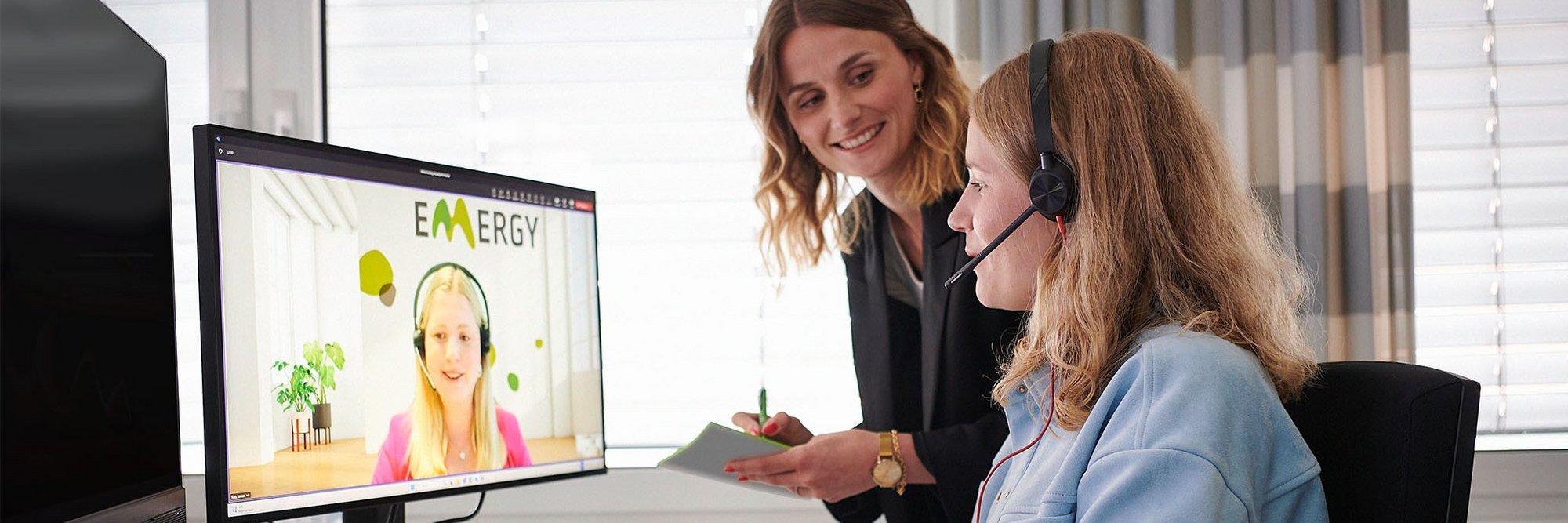 Zwei Frauen vor einem PC in einem Online-Meeting