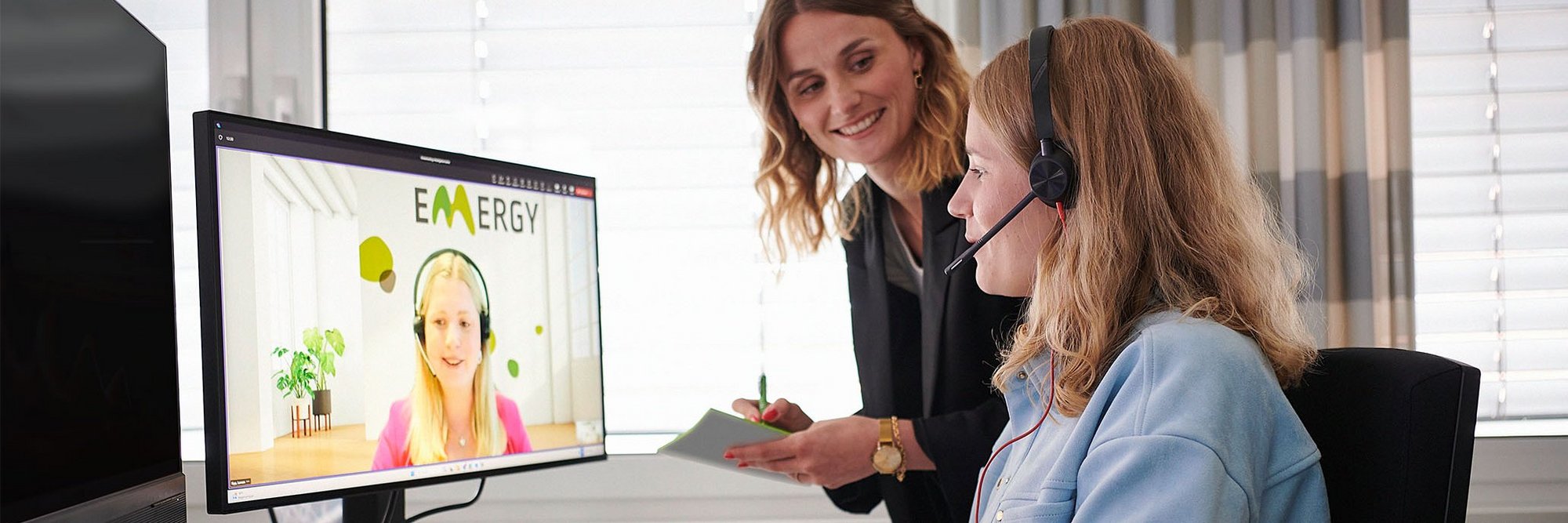 Zwei Frauen vor einem PC in einem Online-Meeting